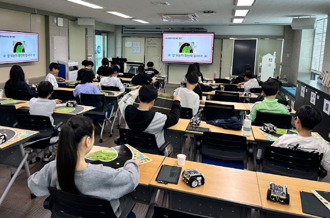 지난 23일 광주서초등학교 학생들이 SW교육지원센터에서 속도를 조절하며 달리는 자율주행 시스템을 코딩한 후 잘 주행하는지 확인하고 있다/광주시교육청 제공