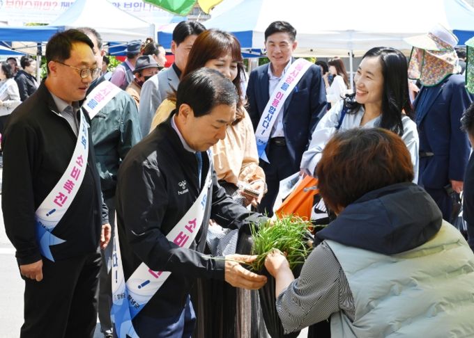 성낙인 창녕군수와 관계자들이 남지시장에서 지역 농산물과 생필품을 구입하며 전통시장 장보기 캠페인에 참여하고 있다.