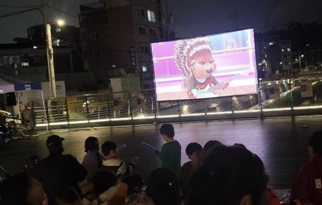 도봉1동 주민들이 누원교 마을마당에서 영화를 보고 있다.