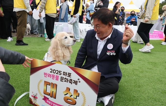 박강수 마포구청장이 반려견 체육대회에서 대상을 수상한 반려견과 함께 기념 촬영을 하고 있다.