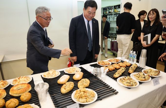 지난 7월 무안군-신세계푸드 협약식에서 무안 양파빵 제품을 살펴보는 김산 군수