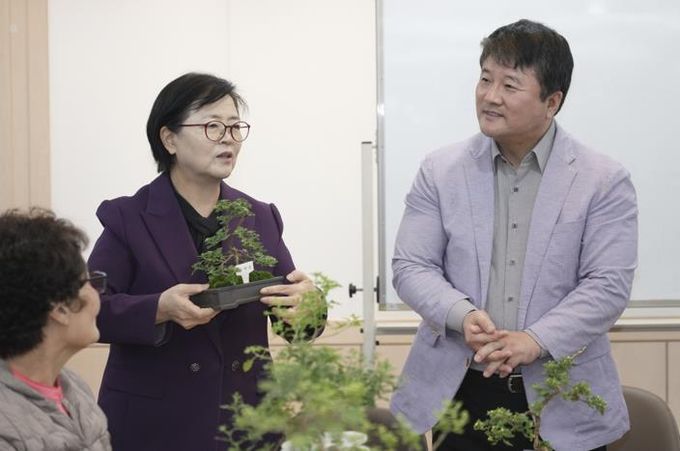 이순희 강북구청장(왼쪽 첫 번째)이 화계중학교를 방문해 최중호 교장과 함께 평생학습 프로그램 ‘국화분재 수업’에 참여한 주민들과 대화를 나누고 있다.