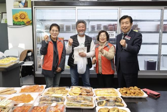 전성수 서초구청장(가장 오른쪽)이 송우학 행복한 반찬 상점주(왼쪽에서 두 번째)에게 재사용을 위한 종이봉투 등을 전달하고 기념사진을 찍고 있다.