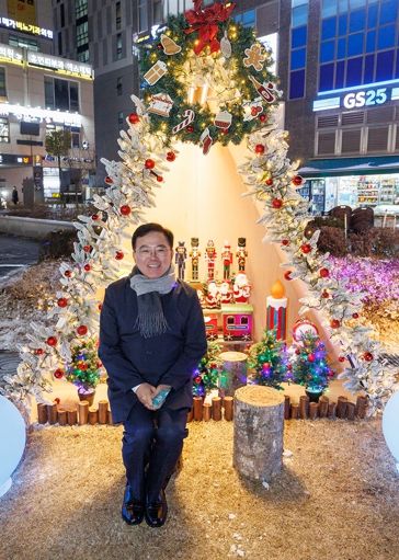 진교훈 서울 강서구청장이 발산역 1번 출구 앞 광장에 조성된 ‘마곡 위시빌리지’ 점등식을 찾아 크리스마스 조형물 앞에서 기념사진을 찍고 있다.