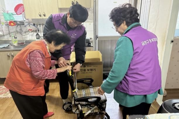 시흥3동 복지협의체 위원들이 어르신에게 실버카를 제공하고 있다