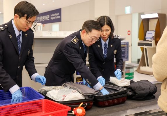 이명구 관세청장(가운데)이 22일 오전 인천국제공항 제1여객터미널에서 직접 여행자 휴대품을 검사하고 있다