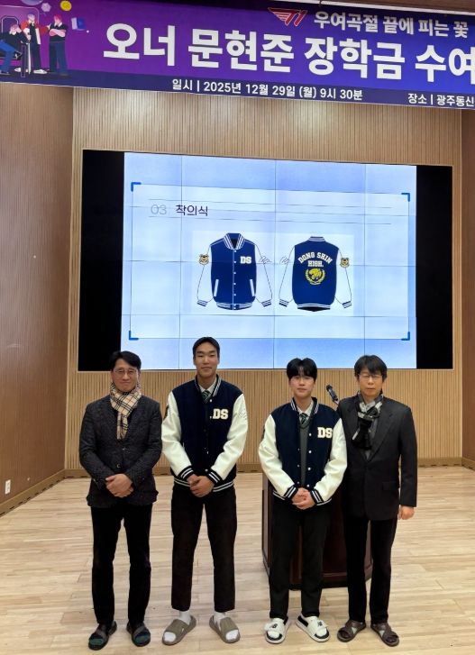 광주동신고 학생들이 문현준 선수의 팬클럽에서 기부한 ‘친필 사인 야구점퍼’를 입어보며 착복식을 진행하고 있다