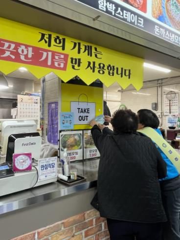 설 명절을 앞두고 경주시 보건소 관계자들이 전통시장 점포를 방문해 '감염병 ZERO 안심 시장' 홍보 스티커를 부착하며 감염병 예방 수칙을 안내하고 있다