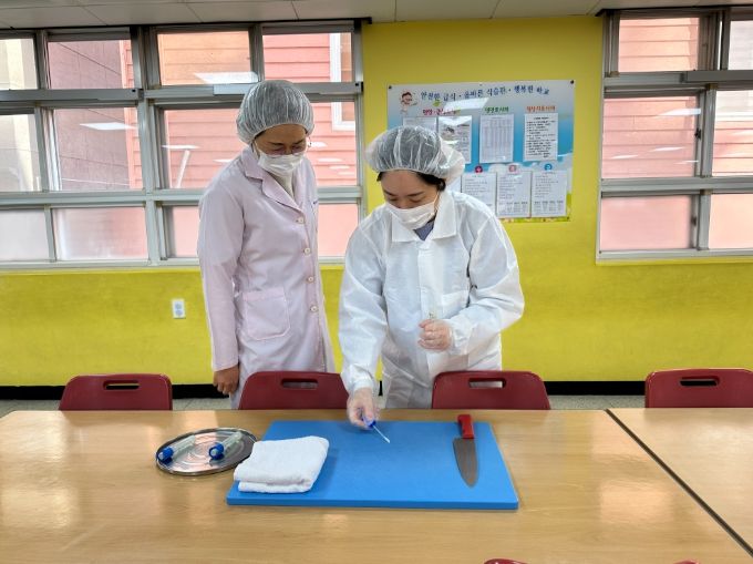 강북교육지원청 담당자가 16일 명촌초에서 학교급식 조리 용구 미생물 검사를 하고자 검체를 채취하고 있다.