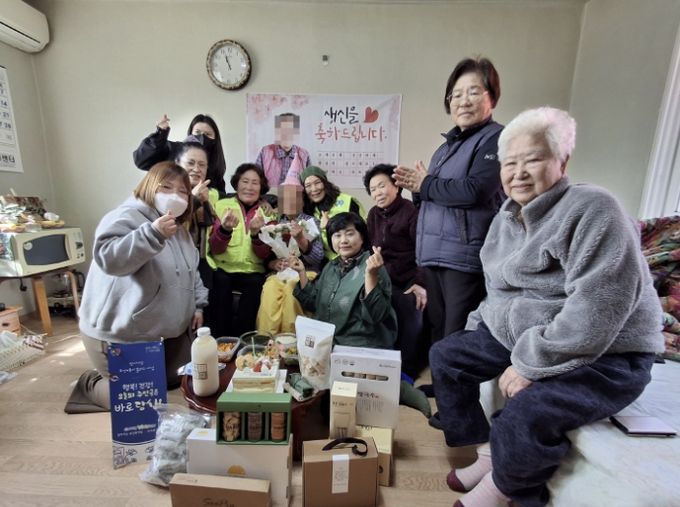 도고면 행복키움추진단 관계자들이 생신을 맞은 취약계층 독거 어르신 가정을 방문해 꽃다발과 생신 음식을 전달하며 기념촬영을 하고 있다.