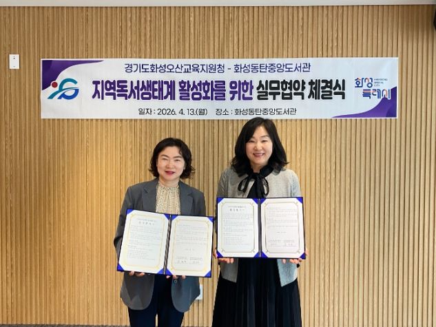 윤미영 화성특례시 도서관정책과장(왼쪽)과 권대은 화성오산교육지원청 평생교육건강과장(오른쪽)이 지역 독서문화 진흥을 위한 실무협약을 체결하고 협약서를 들어 보이며 기념촬영을 하고 있다.