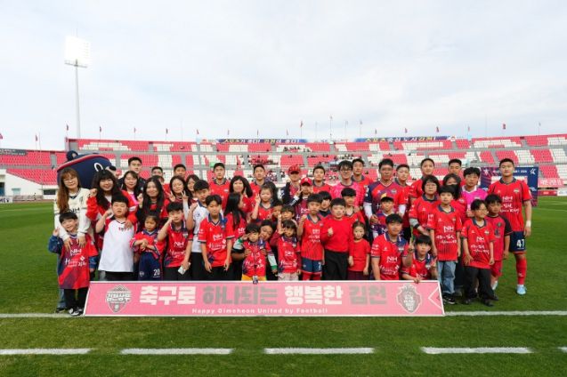 4월 12일 7R 안양전 홈경기에서 김천상무 선수들과 플레이어 에스코트 참가자들이 단체사진을 찍고 있다.